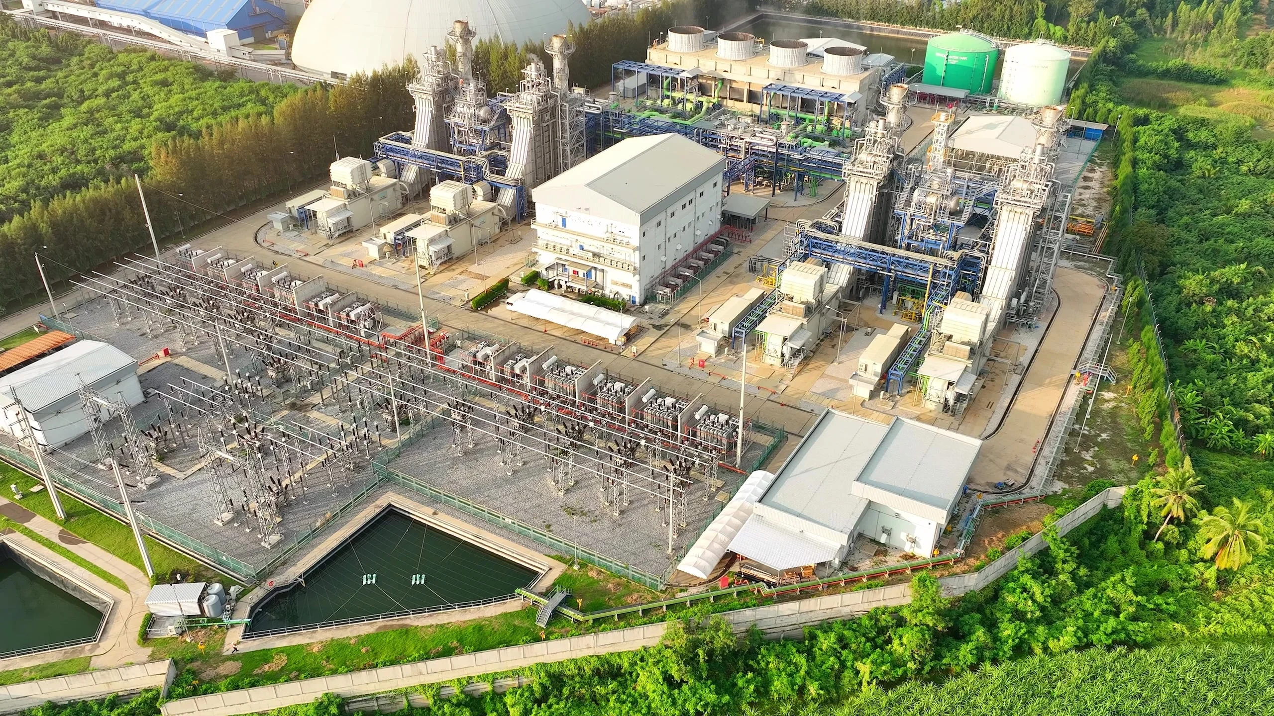 The combined-cycle power plant, viewed from above by a drone, showcases a maze of pipes and turbines, an industrial marvel of efficiency and energy production.