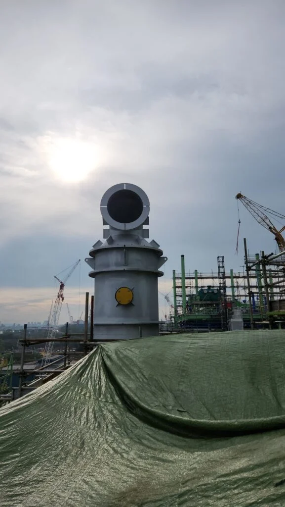 Burgess Manning Vent Silencer used in a processing plant with sun shining behind.